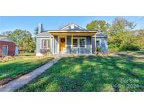 Charming one-story home with a yellow porch at 710 W Elm St, Shelby, NC 28150