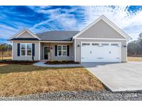 Beige house with white garage door, black shutters, and landscaping at 217 Prospect Church Rd, Albemarle, NC 28001