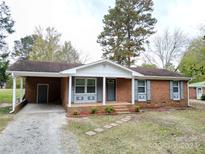 Brick ranch home with a covered carport and landscaping at 192 Allen Pond Rd, Wadesboro, NC 28170