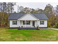 Modern farmhouse exterior with a covered porch and landscaping at 106 Pinecrest Dr, Shelby, NC 28152