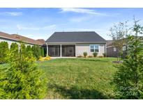 Spacious backyard with a covered patio, lush green lawn, and landscaping at 6235 Scuttle Ln, Denver, NC 28037