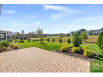 Large brick patio and grassy backyard with landscaping at 6235 Scuttle Ln, Denver, NC 28037