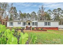 White mobile home with brick skirt and fall decor at 2164 Mission Rd, York, SC 29745