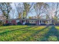 Brick ranch house with a large yard and mature trees at 1218 E Marion St, Shelby, NC 28150