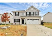 Two-story house with a two-car garage and landscaping at 1707 Scarbrough Sw Cir, Concord, NC 28025