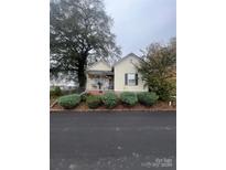 Charming yellow cottage with front porch and well-manicured landscaping at 2 Elm St, Lancaster, SC 29720