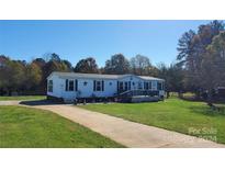 Mobile home with a large front yard and deck at 590 County Line Rd, Stony Point, NC 28678