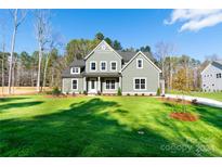 Two-story house with gray siding, white trim, and a large front yard at 1865 Rock Hill Church Rd # 3, Matthews, NC 28104