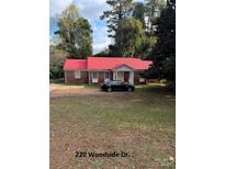 Ranch style brick home with red roof at 220 Woodside Dr, Wadesboro, NC 28170