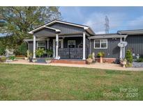 Dark gray house with a covered porch, landscaping, and a large yard at 4298 Maiden Hwy, Lincolnton, NC 28092