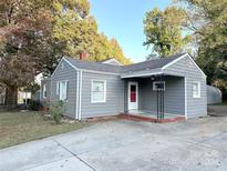 Gray house with a covered porch and mature landscaping at 2310 Belfast Dr, Charlotte, NC 28208