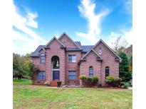 Brick two-story house with a large front yard and mature trees at 119 Plantation Dr, Mooresville, NC 28117