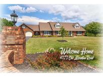 Brick ranch home with landscaped yard and brick pillars at 4723 Old Mountain Rd, Stony Point, NC 28678