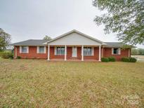 Brick ranch house with covered porch and large yard at 3113 Old Pageland Marshville Rd, Wingate, NC 28174