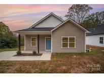 New construction home with taupe vinyl siding and a blue door at 1414 10Th St, Statesville, NC 28677