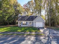 Cute ranch home with gray siding, attached garage, and landscaped lawn at 5019 Poplar Glen Dr, Matthews, NC 28104