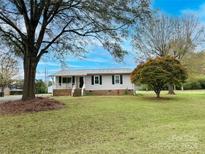 Ranch style home with front porch and landscaping at 1303 Prospectors Ct, Monroe, NC 28110