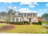 Two-story brick home with landscaped lawn and partial view of neighborhood at 18035 Pawleys Plantation Ln, Charlotte, NC 28278