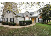 Brick house with yellow door, landscaping, and walkway at 2123 13Th Street Ne Ct, Hickory, NC 28601