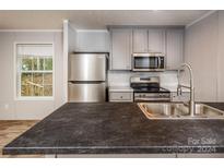 Modern kitchen with stainless steel appliances and gray cabinets at 607 Stewart Ct, Statesville, NC 28677