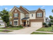 Two-story house with stone accents and a three-car garage at 13929 Tilesford Ln, Huntersville, NC 28078