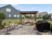 Relaxing patio area with pergola and seating at 13929 Tilesford Ln, Huntersville, NC 28078