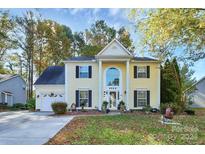 Two-story house with a yellow exterior, landscaping, and a two-car garage at 1846 Colin Creek Ln, Charlotte, NC 28214