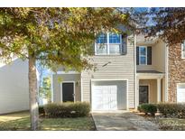 Tan two-story townhome with attached garage and landscaping at 9036 Bradstreet Commons Way, Charlotte, NC 28215