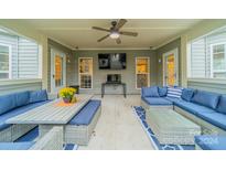 Covered patio furnished with comfortable seating and a large TV at 10126 Loch Lomond Dr, Charlotte, NC 28278