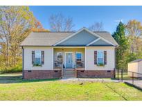 Tan and gray sided home with brick base, shutters, and landscaping at 530 Denton Ave, Chester, SC 29706