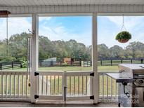 Screened back porch overlooks a fenced-in backyard with a peaceful country view at 1854 Garvin Rd, York, SC 29745