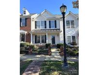 Two-story townhome with brick and siding, featuring a front porch and landscaped yard at 17734 Delmas Dr, Cornelius, NC 28031