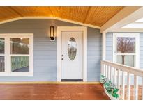 Inviting front porch with white door and wood ceiling at 5112 Green Leaf Ct, Mount Holly, NC 28120