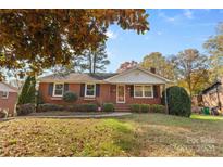 Brick ranch home with a landscaped yard and inviting front porch at 1532 Starbrook Dr, Charlotte, NC 28210
