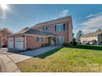 Brick townhouse with two-car garage and landscaped lawn at 4335 Laurel Hill Ln, Charlotte, NC 28217
