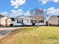 Ranch style home with gray siding, a paved driveway and a well-manicured lawn at 5136 Wheat Sw Dr, Concord, NC 28027