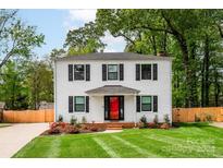 Two-story white house with black shutters, red door, and a well-maintained lawn at 7704 Cedar Bluff Ln, Charlotte, NC 28227