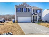 Two-story house with gray siding, a two-car garage, and a well-maintained lawn at 7865 Whispering Stream Dr, Sherrills Ford, NC 28673
