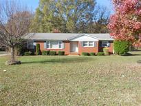 Ranch style brick home with a spacious front yard and mature trees at 6901 Wilson Grove Rd, Mint Hill, NC 28227