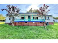 Charming ranch home with a covered porch and well-maintained lawn at 142 Swink Sw St, Concord, NC 28027