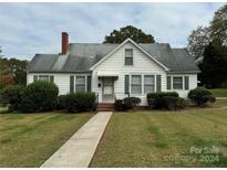 White house with green bushes, walkway, and carport at 1716 3Rd Ne St, Hickory, NC 28601