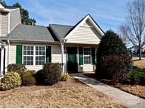 Inviting exterior of a charming tan home with green shutters and landscaping at 7374 Sun Dance Dr, Fort Mill, SC 29707