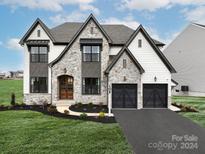 Two-story house with stone accents and a three-car garage at Lot 47 Watercourse Way # Devonshire, Belmont, NC 28012