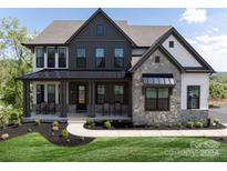 Two-story farmhouse with gray siding, stone accents, and a metal roof at Lot 42 Watercourse Way # Hawthorne, Belmont, NC 28012