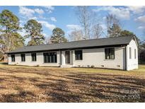 Ranch style home with white brick exterior, dark windows, and a gray roof at 3700 Pinecrest Dr, Gastonia, NC 28056