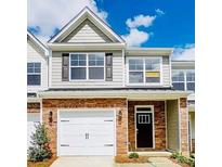 Charming two-story townhome with a brick facade and two-car garage at 3950 Rothwood Ln, Harrisburg, NC 28075