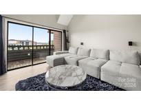 Spacious living room with sectional sofa, balcony access, and city views at 9039 J M Keynes Dr # 19, Charlotte, NC 28262