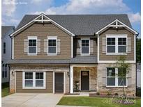 Two-story home with gray shake and brick accents, landscaped lawn, and attached garage at 1703 Coral Bark Ln # Kh01, Charlotte, NC 28216