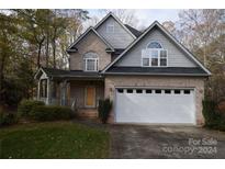 Brick two-story house with a white garage door and landscaping at 809 Pine Forest Rd, Charlotte, NC 28214
