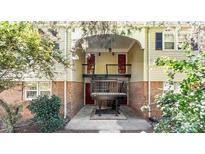 Two-story condo building with brick and siding exterior, featuring a covered entryway and landscaping at 4605 Coronado Dr, Charlotte, NC 28212
